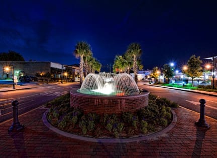 a water fountain in the middle of a street at night