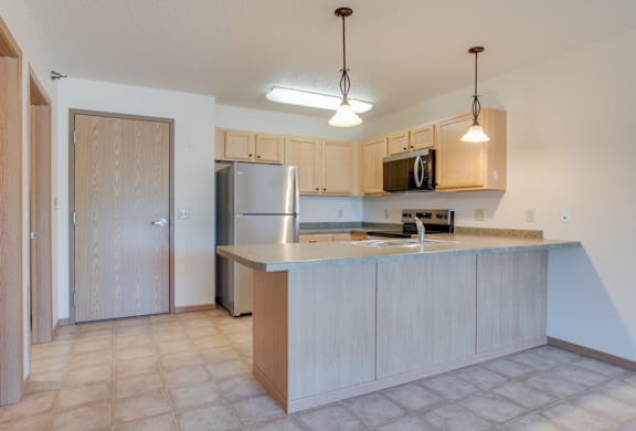 an open kitchen with white appliances and wooden cabinets