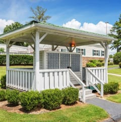 a white gazebo with a porch in a yard