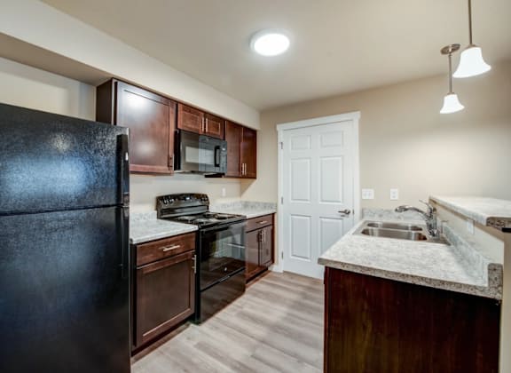 a kitchen with black appliances and a black refrigerator