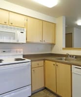 an empty kitchen with a stove microwave and sink at Troutdale Terrace, Troutdale,  97060