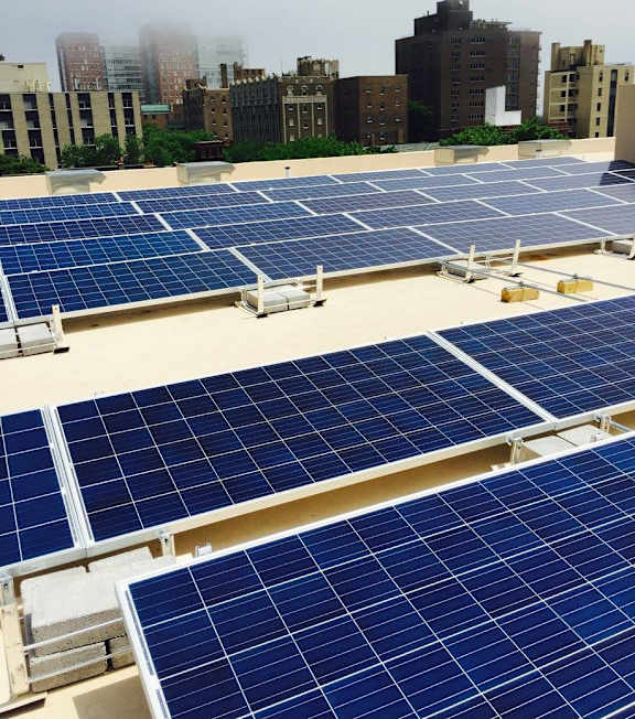 A large array of solar panels are installed on a rooftop.