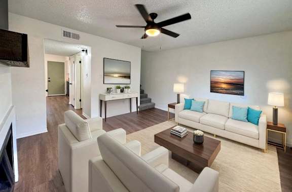 A living room with a white couch and a wooden coffee table.