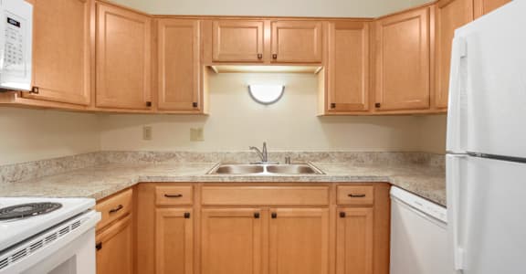 A kitchen with wooden cabinets and a white refrigerator.
