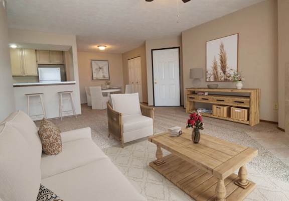 A living room with a white couch, a wooden coffee table, and a ceiling fan.