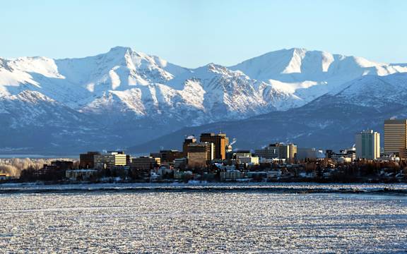 A cityscape with snow-capped mountains in the background.