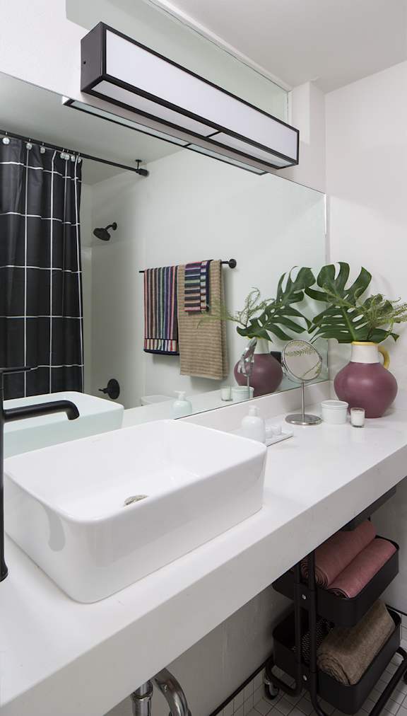 a white bathroom with a sink and a mirror at The Flat in Los Angeles, California