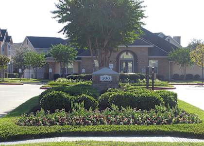 a roundabout in front of a house with a tree in the middle of the roundabout