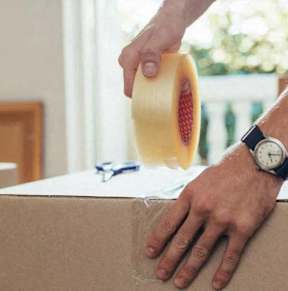 A person is taping a cardboard box.