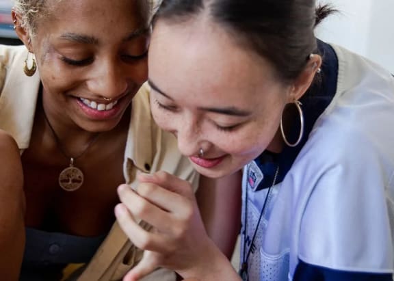 two women looking at a cell phone