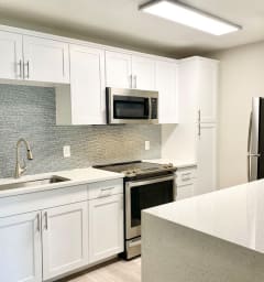a kitchen with white cabinets and a counter top at La Jolla Blue, San Diego, CA, 92122