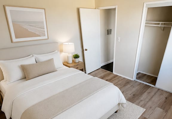 A bedroom with a large bed and a wooden floor.