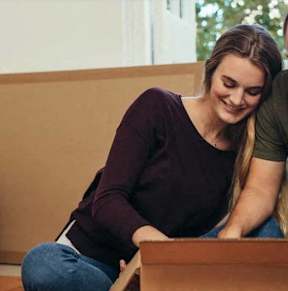 A man and woman are unpacking a box together.