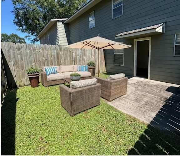 A backyard with a patio set and a wooden fence.