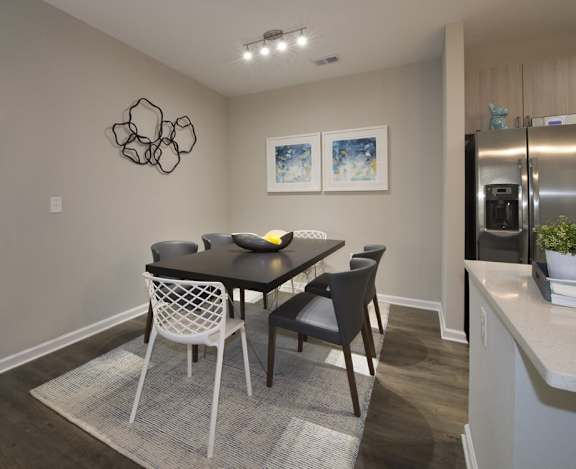 Dining room with overhead lighting and hardwood-inspired flooring