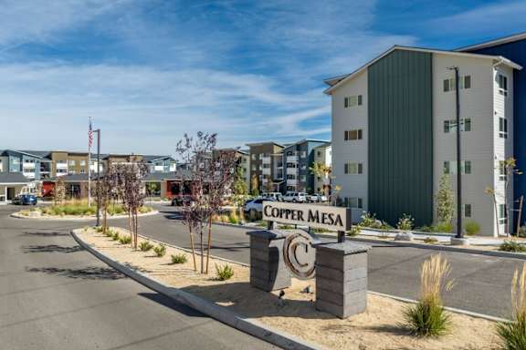 The image shows a street view of the Copper Mesa apartment complex with a sign in the foreground.