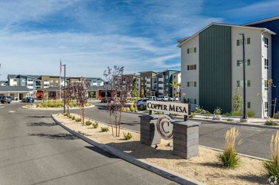 The image shows a street view of the Copper Mesa apartment complex with a sign in the foreground.
