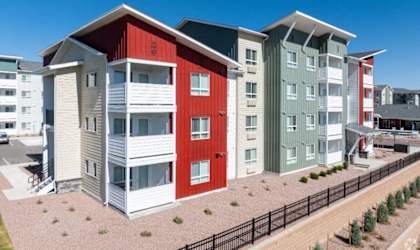A row of modern townhouses with red, white, and green exteriors.