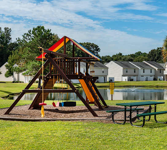 A playground with a slide and a picnic table at The Islands in Charleston SC