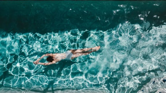 Woman swimming in pool at Mirabella Apartments, 92203, CA