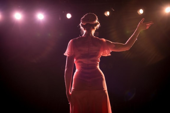 Woman waving on stage at Mirabella Apartments, Bermuda Dunes, 92203