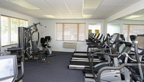 a room filled with lots of cardio equipment and weights