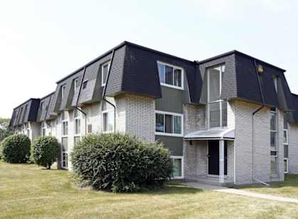 an apartment building with a yard in front of it