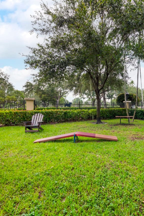 a park with a playground and skateboards on the grass