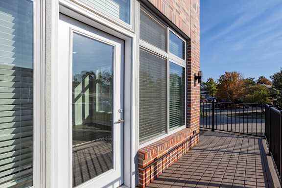 the balcony of a home with windows and a door