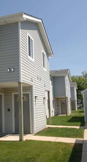 a white garage with a gray roof and a driveway