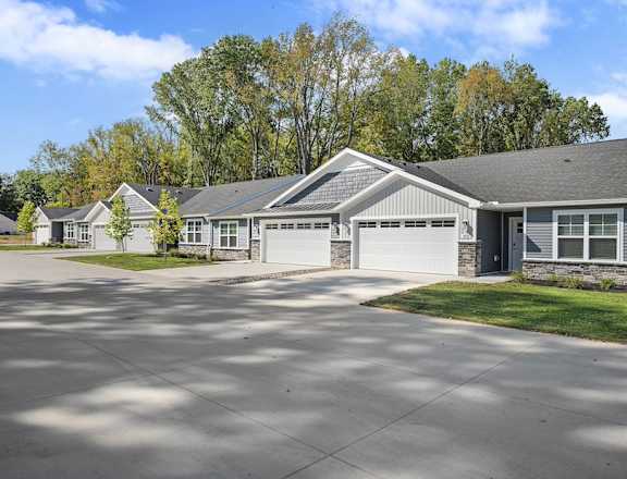 A house with a grey roof and a driveway in front.