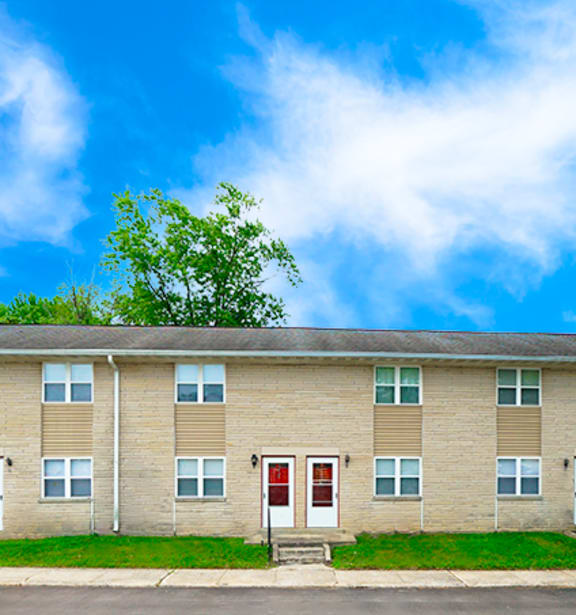 Apartment building with a green lawn in front.