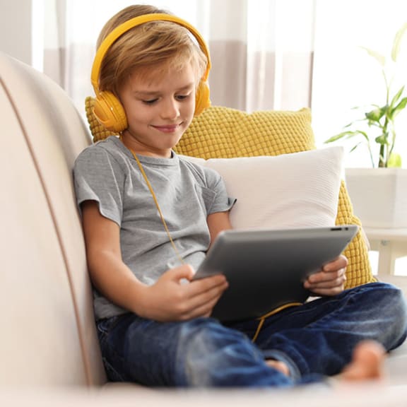Child on couch with tablet