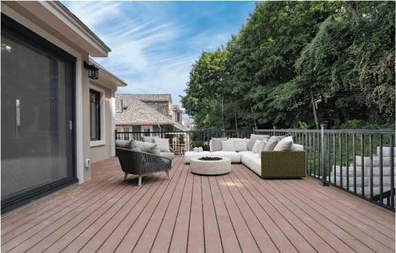 a backyard deck with furniture and a fire pit