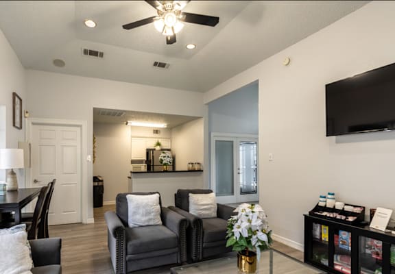 A living room with a grey couch and a black chair.