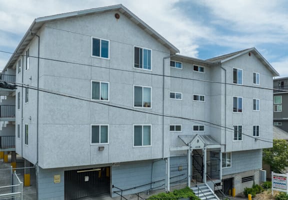 A large white building with a parking lot in front.