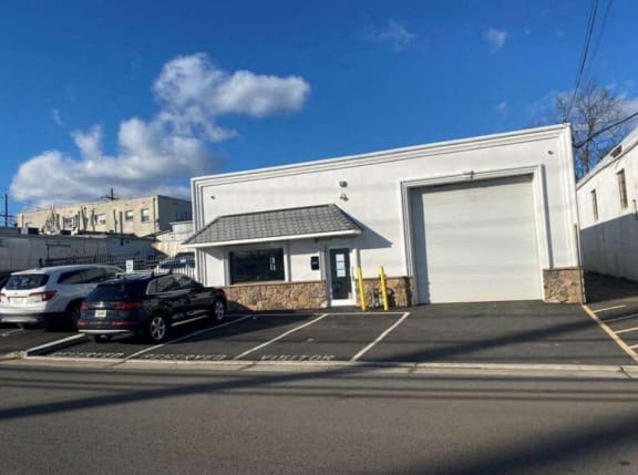 a parking lot with cars in front of a white building