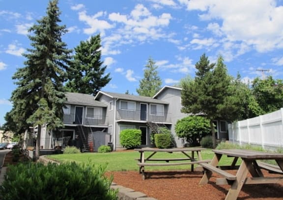 A sunny day at a residential complex with a picnic table in the foreground.
