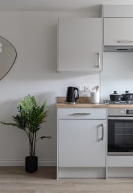 a modern kitchen with grey cabinets and black appliances