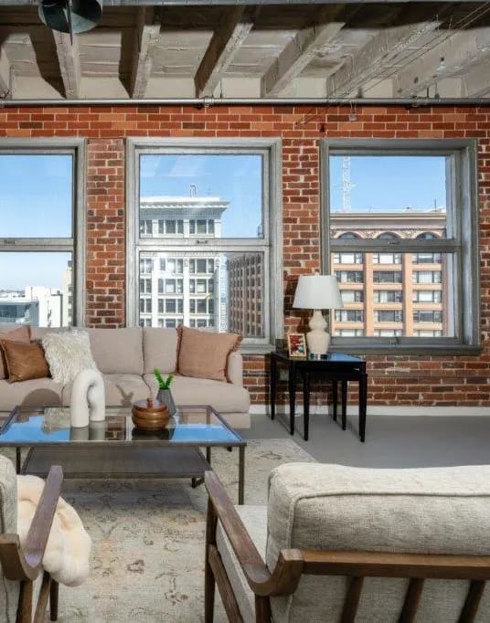 a living room with a couch and a brick wall