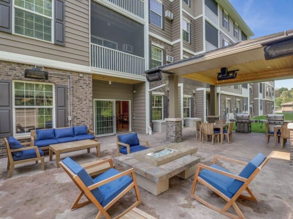 an outside patio with chairs and tables and a fire pit
