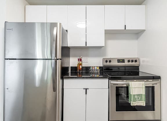 A modern kitchen with a stainless steel refrigerator and oven.