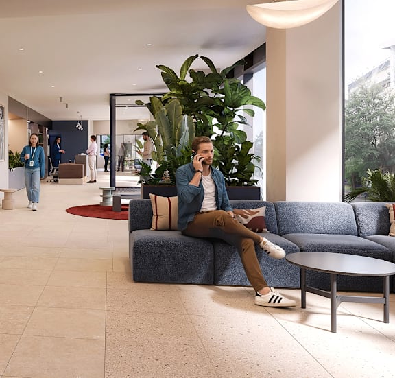 A man is sitting on a couch at Podium Apartments, Stretford