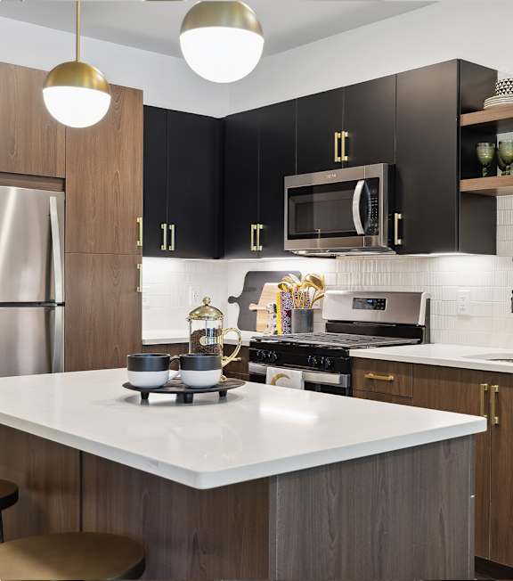 A modern kitchen with a white countertop and black cabinets.