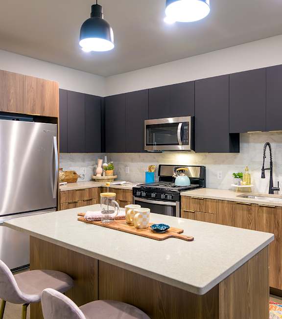 A kitchen with a white countertop and wooden cabinets.