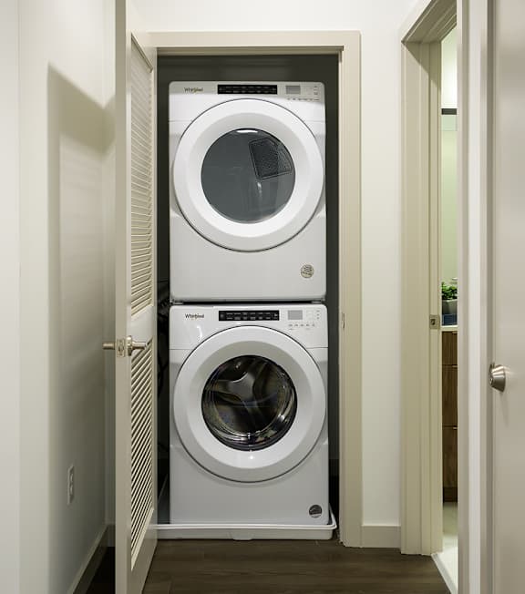 A white front load washer and dryer in a small laundry room.