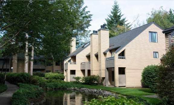 a large house with a pond in front of it