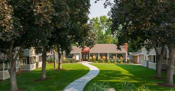A pathway leads to a building surrounded by trees.