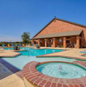 swimming pool surrounded by beach chairs and building