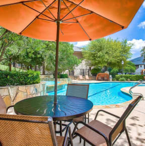 a patio with a pool and a table with an umbrella